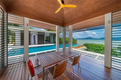 a dining room with a table and chairs on a deck at Villa Elegance Luxury Ocean View Pool Villa with Breakfas & Daily Maid Service in Ko Lek