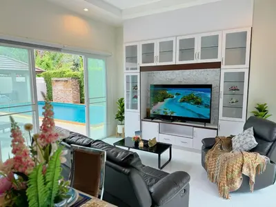 a living room with a large tv and a couch at shine bright villa in Ban Saiyuan (1)