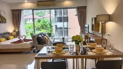 a living room with a table and a living room with a couch at A Well Equipped Condo near Karon Beach in Karon Beach