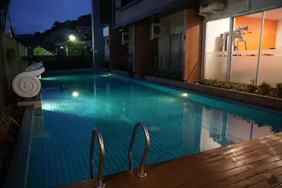 a swimming pool in a building at night at A Well Equipped Condo near Karon Beach in Karon Beach