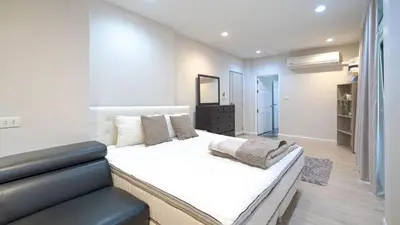a bedroom with a large white bed and a couch at 5BR Lucky Pool Villa Kathu Golf - 12 guest in Kathu