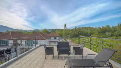 a deck with chairs and tables on a balcony at 5BR Lucky Pool Villa Kathu Golf - 12 guest in Kathu