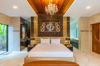 a bedroom with a bed and a chandelier at Noi's Villa - tropical oasis with pool and maid in Kamala Beach