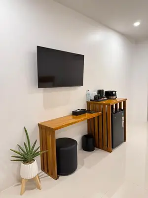 a living room with a television on a wall at Veeyava Bangtao House in Surin Beach