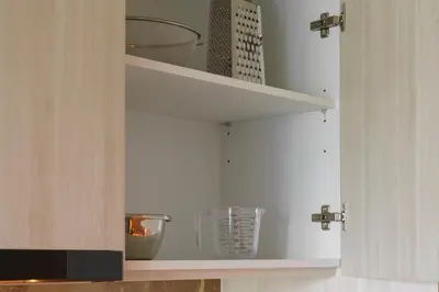 a kitchen cabinet with shelves with bowls and utensils at The Ozone Terracotta Art Golf View Bangtao in Laguna Phuket