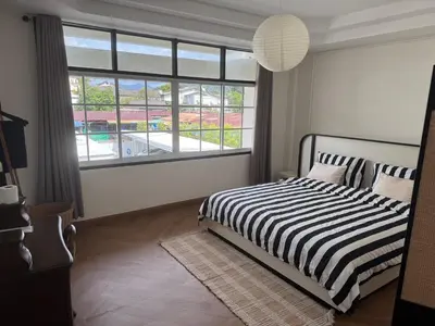 a bedroom with a bed and a large window at bége in Ban Lo Long