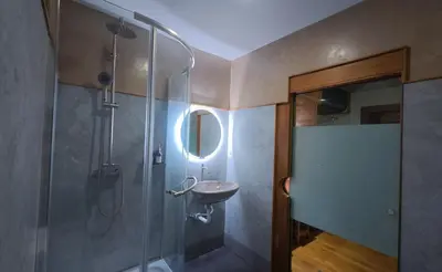 a bathroom with a shower with a sink and a mirror at Salty Pearl Phuket 2 in Patong Beach