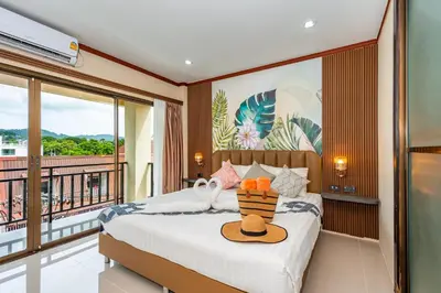 a bedroom with a bed and a balcony at The Outdoor Kata Hotel in Kata Beach