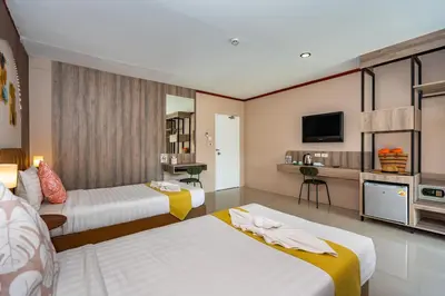 a hotel room with two beds and a tv at The Outdoor Kata Hotel in Kata Beach