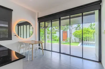 a dining room with a table and large windows at V242 Prime Location 2BR with Pool&Garden Near Beach in Bang Tao Beach