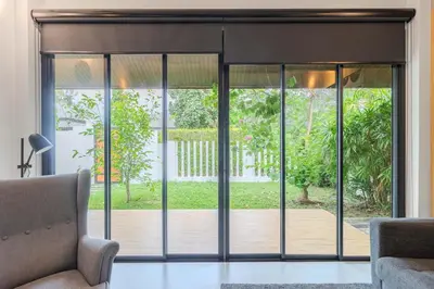 a living room with sliding glass doors to a patio at V243 Quite 3BR Pool Villa Bathtub Near Beach in Bang Tao Beach