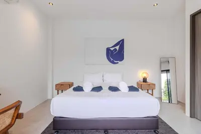 a bedroom with a large white bed with a nike sign on the wall at V243 Quite 3BR Pool Villa Bathtub Near Beach in Bang Tao Beach