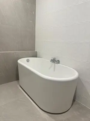 a white bath tub in a white tiled bathroom at House No 21-77 Near bangtao beach Phuket in Koh Lone