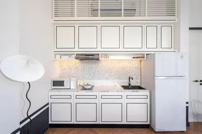 a kitchen with white cabinets and a white refrigerator at MONO Villa Bang Tao 3 bedroom modern pool villa in Ban Pak Lak