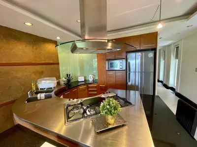 a kitchen with a stainless steel counter top and a stove at Kata Eden View - 1 BR Beachfront Luxury Apartment in Karon Beach