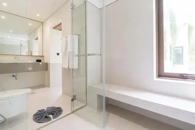 a bathroom with a glass shower and a toilet at Qabalah by Villacarte in Ban Pak Lak