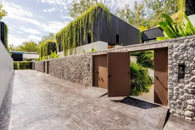an exterior view of a house with a stone wall at Qabalah by Villacarte in Ban Pak Lak