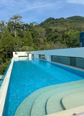 a large blue swimming pool on top of a building at Fantasea Condo Kamala in Kamala Beach