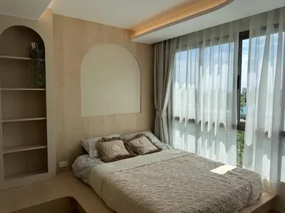 a bedroom with a bed and a large window at Fantasea Condo Kamala in Kamala Beach