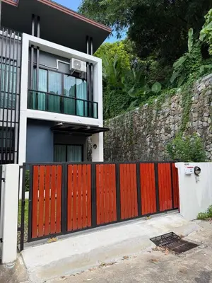 a house with a red gate and a wall at Town House European Style in Ban Ket Ho