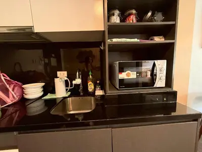 a kitchen counter with a microwave and a sink at The Deck Patong Phuket by Mickey in Patong Beach