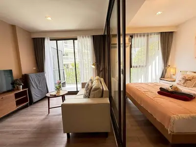 a bedroom with a large bed and a television at The Deck Patong Phuket by Mickey in Patong Beach