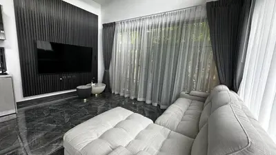 a living room with a white couch and a television at Exclusive 2BR Pool Villa in Ban Saiyuan (1)