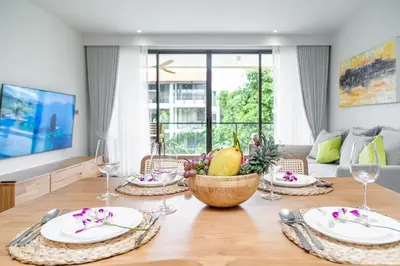 a dining room table with plates and a bowl of fruit at Beachside 2 bedrooms apartment 200 meters to Bang Tao Beach Manage by OCEAN HUB in Bang Tao Beach