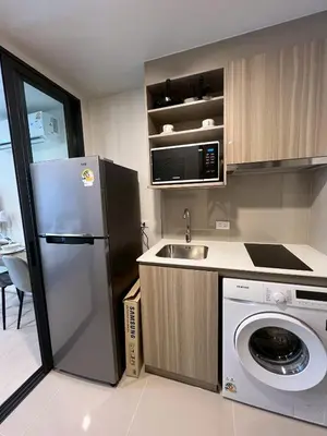 a kitchen with a refrigerator and a sink at The Base Rise Central Phuket in Ban Rangeng