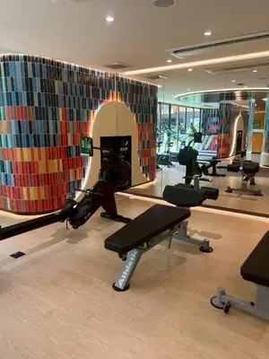 a gym with several treadmills and a wall of mirrors at The Base Rise Central Phuket in Ban Rangeng