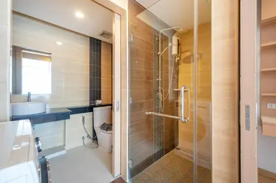 a bathroom with a glass shower with a toilet at Hillside 2BR Apartment with Pool & Gym 5 Min to Kamala Beach 48RK in Kamala Beach