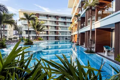 a large swimming pool with palm trees in front of a building at Sunshine Beach Luxury 3-bedrooms with a great view in Layan Beach