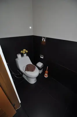 a black bathroom with a toilet and a bidet at Duangjai Residence, Rooms & Apartments in Rawai Beach