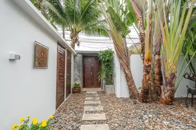 a courtyard with palm trees next to a house at New Primrose Pool Villa Your Own Secluded Paradise in Rawai Beach