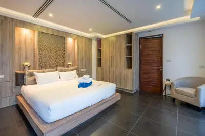 a bedroom with a large white bed and a chair at New Primrose Pool Villa Your Own Secluded Paradise in Rawai Beach