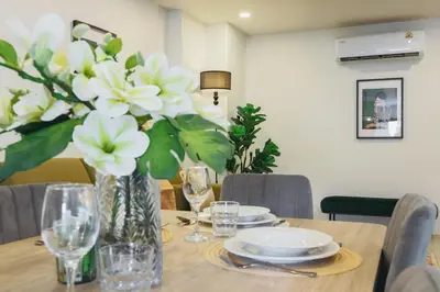 a dining room table with a vase of white flowers at Wink Hill 1 Penthouse Patong 4 Bedrooms in Patong Beach