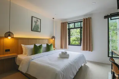 a bedroom with a large white bed with green pillows at Wink Hill 1 Penthouse Patong 4 Bedrooms in Patong Beach