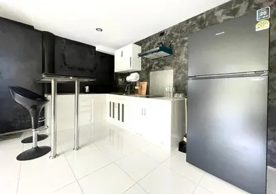 a kitchen with a stainless steel refrigerator and white cabinets at Quiet Seaview House 1 Bedroom Patong in Patong Beach