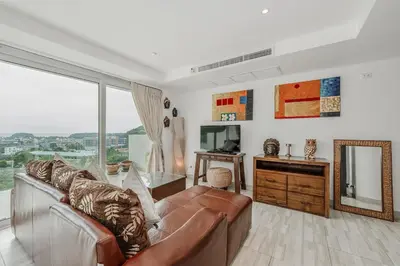 a living room with a couch and a television at C236 Best Pool &Sea View 2BR Condo Prime Location in Karon Beach