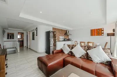 a living room with a brown leather couch at C236 Best Pool &Sea View 2BR Condo Prime Location in Karon Beach
