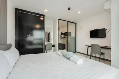 a bedroom with a large white bed with two pillows on it at C237 Brand New 1BR Condo Pool Gym Near Beach in Bang Tao Beach