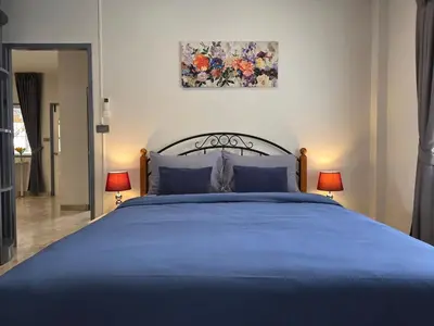 a bedroom with a blue bed with two lamps at Moonlight Naka in Ban Rangeng