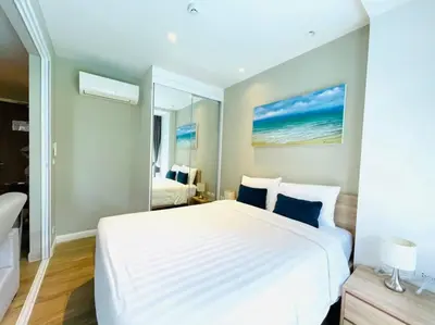a bedroom with a large white bed with blue pillows at Daimond resort condominium by koy in Patong Beach