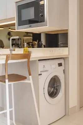 a kitchen with a washing machine and a microwave at Cassia Exclusive Lake View Condo Bang Tao Beach in Phuket Town