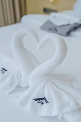 two swans wrapped in white towels on a table at Cassia Exclusive Lake View Condo Bang Tao Beach in Phuket Town
