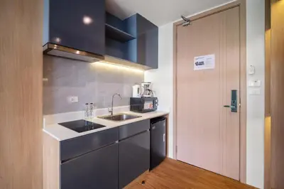 a small kitchen with a sink and a door at Wyndham Gardens 1321 Studio 1min to Naithon Beach in Phuket Town