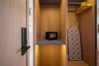 a room with a closet with a clock on a shelf at Wyndham Gardens 1321 Studio 1min to Naithon Beach in Phuket Town