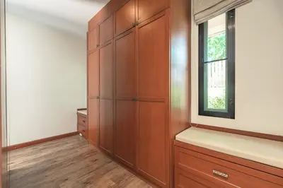 a dressing room with wooden cabinets and a window at 3 Bedrooms villa walking distance to Rawai beach in Rawai Beach
