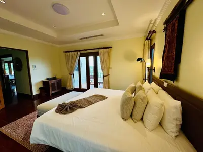 a bedroom with a large bed with white sheets and pillows at \u6574\u680b\u9ad8\u5962\u5eb7\u517b\u6cf3\u6c60\u522b\u5885 - \u5e26\u53a8\u5e08\u5973\u4f63 in Layan Beach