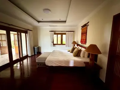 a bedroom with a bed and a lamp in it at \u6574\u680b\u9ad8\u5962\u5eb7\u517b\u6cf3\u6c60\u522b\u5885 - \u5e26\u53a8\u5e08\u5973\u4f63 in Layan Beach